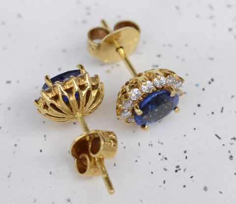 Natural Ceylon Blue Sapphire center piece earrings surrounded by 24 diamonds set in 18K carat yellow gold available at Elizabeth Jewellers in Sri Lanka