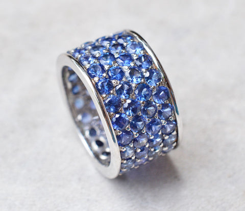 Thick band ring with four rows of blue sapphires paved in 18K white gold