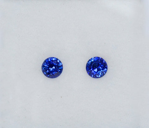 A pair of dark blue round shaped blue sapphires